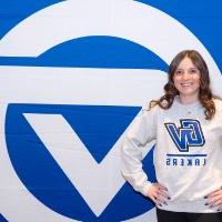 girl poses in front of gv backdrop with GVSU sweatshirt